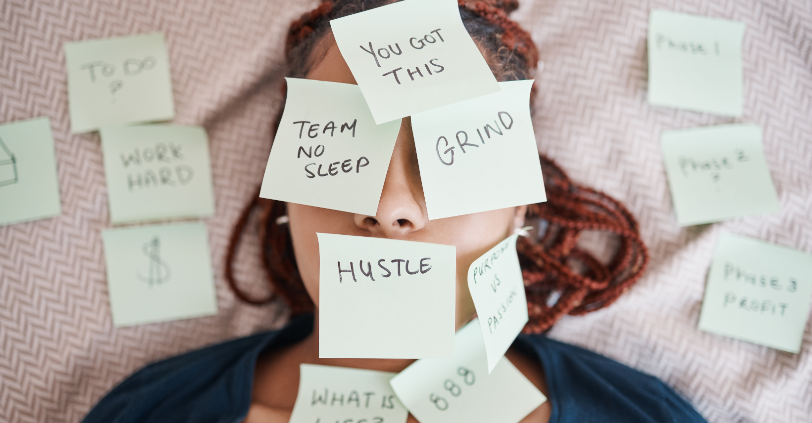 Overwhelmed woman laying on bed covered in post-it notes